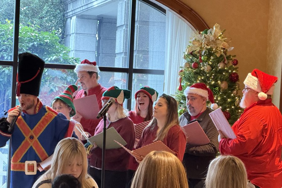 Festively dressed carolers singing holiday songs at the O.Henry Hotel Nutcracker Tea.
